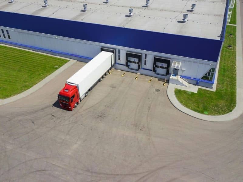 Roadway Engineer Truck Turning | Huntsville Civil Engineering Aerial view of a tractor-trailer turning beside a warehouse loading area, illustrating roadway engineer truck turning analysis
